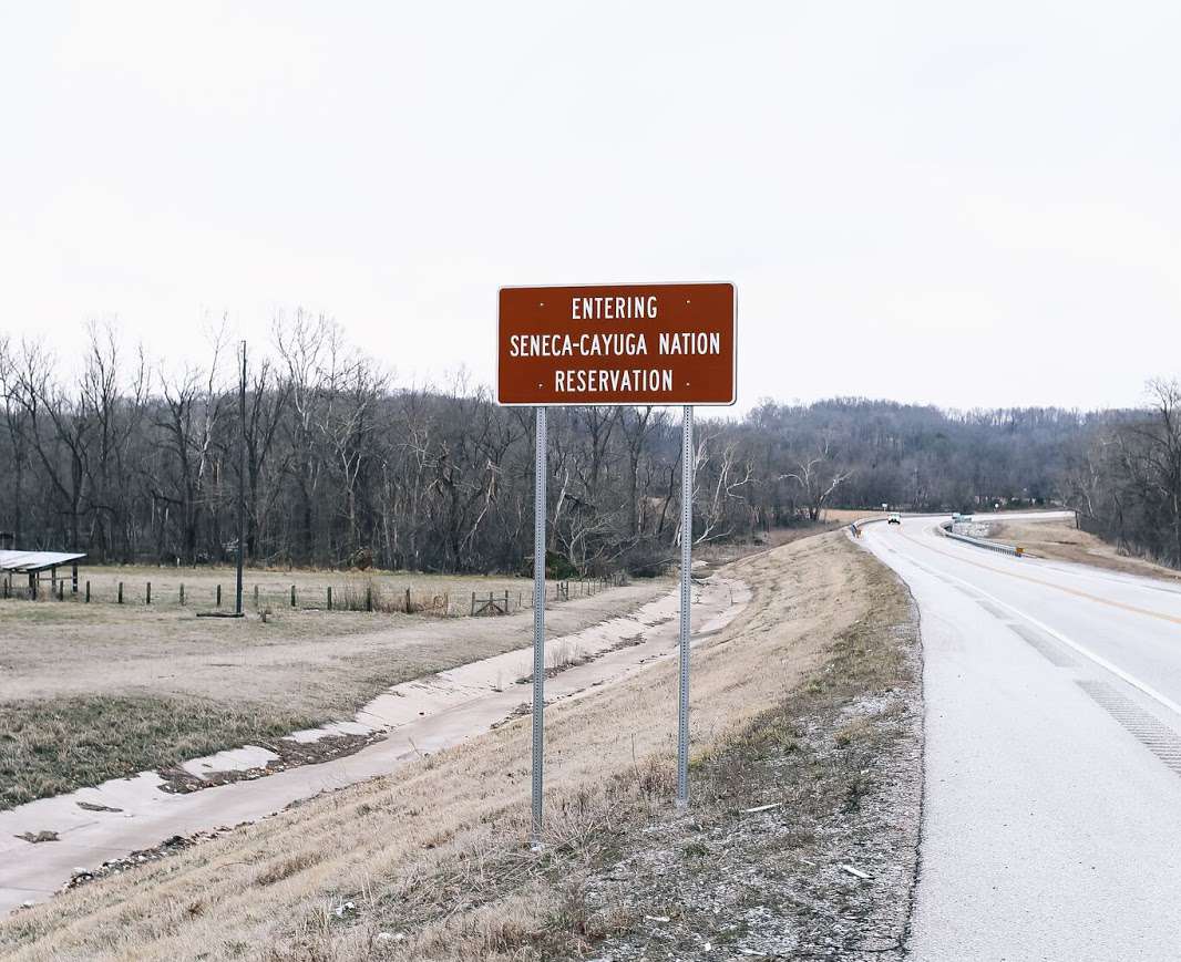 image of road sign that says "entering seneca-cayuga nation reservation"