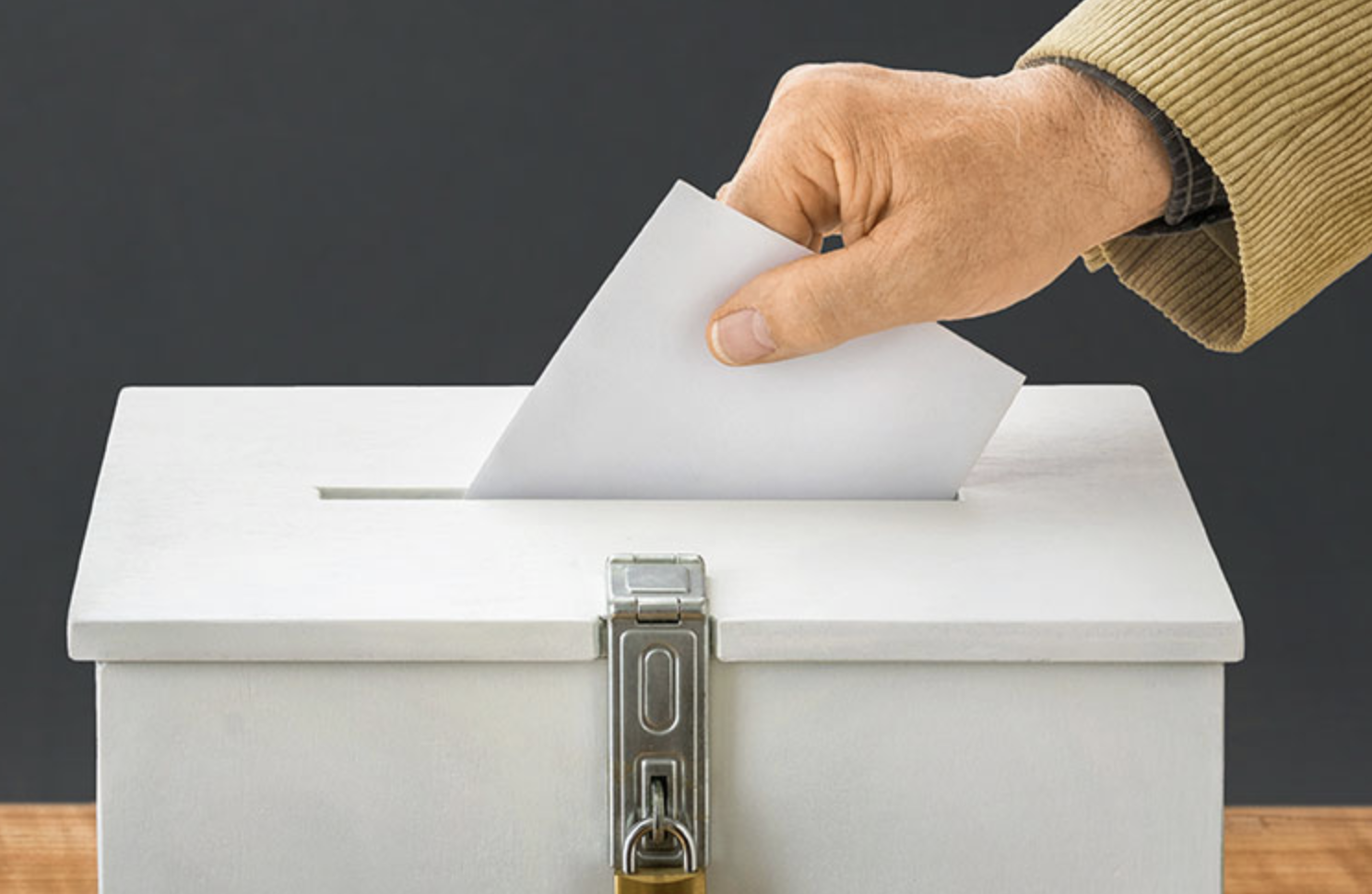 image of voter placing ballot in ballot box