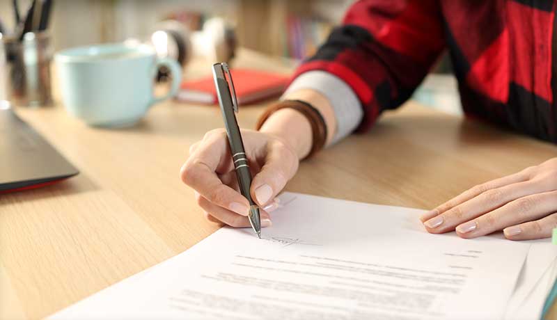 Photo of a person signing papers