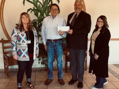 Chief Diebold handing a check to Grove Public School Officials