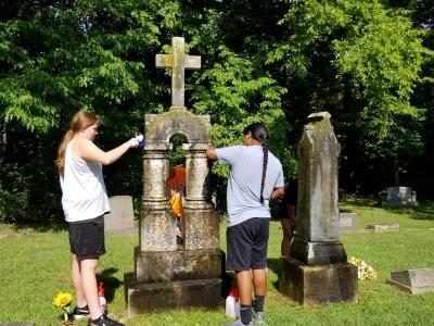 image of Tribal Members Volunteering to clean headstone at our cemetery