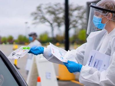 image of healthcare worker handing out COVID test