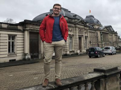 image of sam quick standing on railing in front of beautiful building