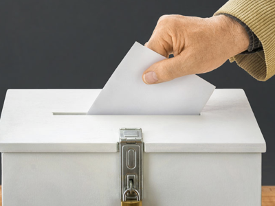 image of voter placing ballot in ballot box